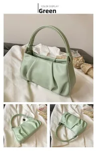 Detail of light green pleated handbag with secure zipper and leather texture