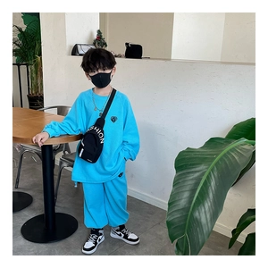 Detail of blue oversized sweatshirt with heart embroidery and black crossbody bag for boys