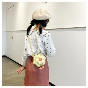 Cute girl wearing a yellow flower-shaped mini crossbody bag with a white floral detail