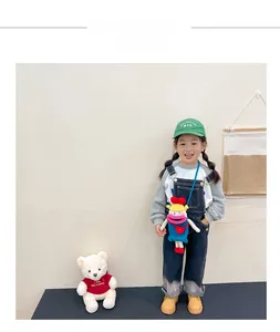 Close-up of cute blue knitted cartoon crossbody bag with funny big mouth on child model