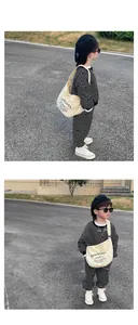 Outdoor lifestyle shot of a boy wearing a striped tracksuit and canvas crossbody bag