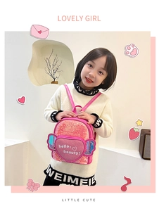 Girl wearing pink sequin backpack with heart pocket and blue wings decoration