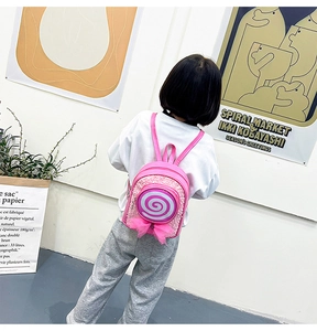 Pink sequin girls backpack with lollipop design and mesh bow shown on a child model