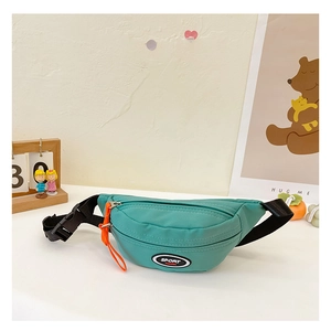 Detail der grünen Kinder-Brusttasche mit SPORT FASHION-Logo und orangefarbenem Reißverschluss