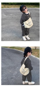 Outdoor shot of a cool boy wearing a striped sweatshirt and cream canvas crossbody bag
