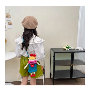 Close-up of a handmade colorful crochet cartoon crossbody bag worn by a young girl