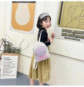 Girl wearing white sequin lollipop backpack with pink mesh bow in a modern setting