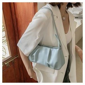 Side view of light blue pleated cloud bag in premium PU leather with slim shoulder strap