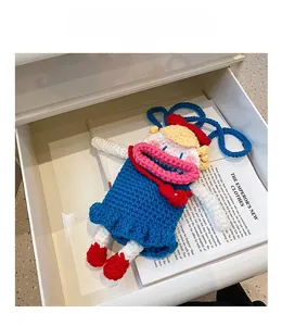 Detailed macro view of a handmade cartoon knitted doll crossbody bag with vibrant stitching