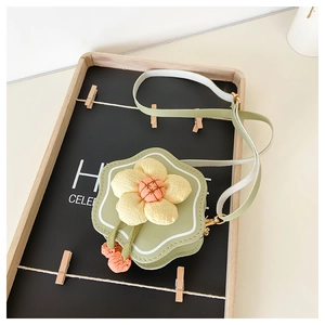 Detail view of flower-shaped crossbody bag in light green PU leather and yellow fabric