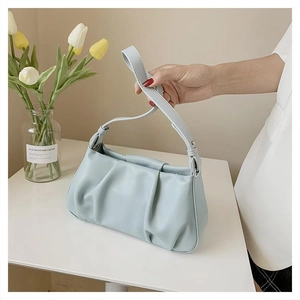 Close-up of the light blue pleated texture and metal zipper on a stylish cloud bag
