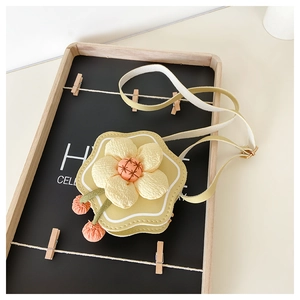 Detailed view of yellow flower-shaped mini shoulder bag with 3D petals and fringe tassels
