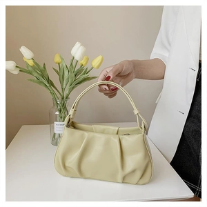 Detailed view of the pleated texture and soft yellow PU leather on this stylish cloud bag