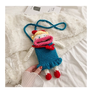 Detail of handmade crochet cartoon doll crossbody bag with vibrant colorful knitted texture