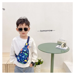 Detail of blue canvas kids crossbody bag with colorful cartoon dinosaur prints and strap