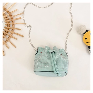 Detail of mint blue rhinestone mini bucket bag with silver chain strap and drawstring closure