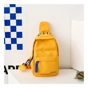 Macro shot of bright yellow kids canvas crossbody bag with multi-pocket design and strap