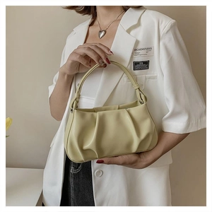 Detailed macro view of the light yellow ruched PU leather texture on a cloud bag