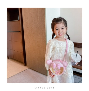 Détail d'un petit sac rond rose pour fille avec paillettes et oreilles mignonnes