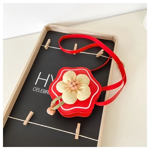 Close-up of red flower-shaped children's crossbody bag with yellow floral 3D detail