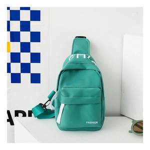 Detail of mint green canvas chest bag with white fashion lettering and wide strap