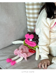 Détail du sac poupée en tricot fait main montrant la texture fine du crochet rose