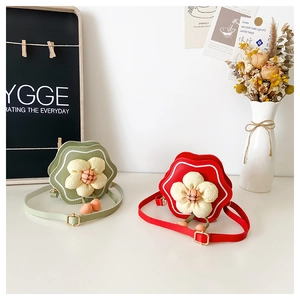 Detail of red and green flower shaped mini PU crossbody bags with floral center