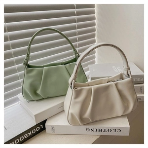 Detail of pleated cloud handbags in bean green and cream white with knotted handle style