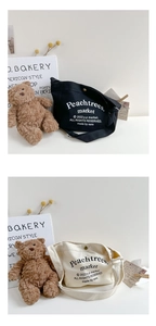 Detail of canvas crossbody bags in black and beige with Peachtrees market logo