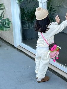Détail du sac bandoulière en tricot pour enfant avec charm fraise porté dehors