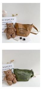 Close-up of canvas crossbody bag with metal snap button and adjustable shoulder straps