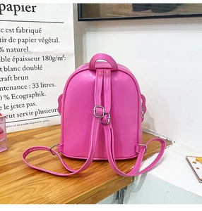 Pink sequin girls backpack with adjustable silver straps on a wooden table detail