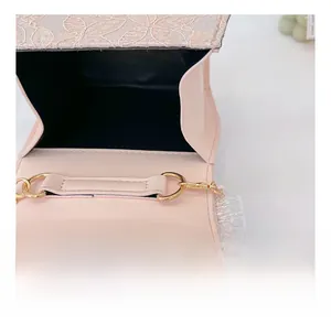 Détail du sac en dentelle rose avec bouton pression magnétique doré et doublure noire