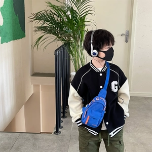 Kids blue canvas crossbody chest bag styled with a baseball jacket and cargo pants