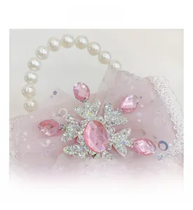 Detail von rosa Strass-Schneeflocke und Perlen-Griff an Mädchen-Spitzenhandtasche