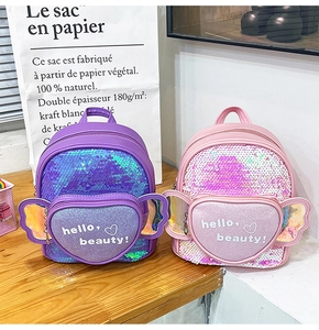 Detail of gradient sequin mini backpacks with heart pockets and holographic wings