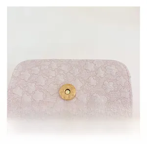Detailansicht der rosa Schleifen-Handtasche mit goldenem Magnetverschluss und Textur