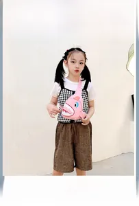 Detailed close-up of a pink cartoon shark canvas crossbody bag for kids on a model