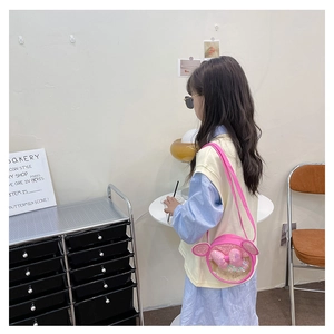 Vue détaillée du petit sac bandoulière rose à paillettes pour fille avec un nœud