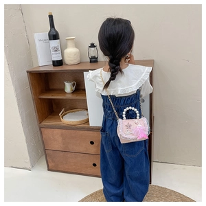 Fille portant un sac à main princesse rose avec poignée en perles et chaîne en métal