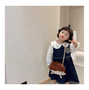 Gros plan d'un sac hérisson en tricot porté avec une robe en jean bleu pour enfant