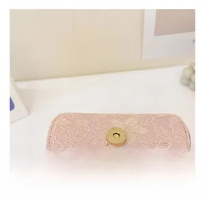 Macro detail of golden magnetic buckle on pink lace bag with exquisite texture