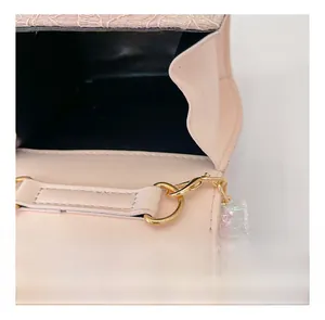 Detail view of pink girl's handbag interior showing golden hardware and sequins