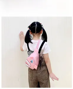 Pink canvas shark crossbody bag for kids shown in use with adjustable shoulder strap