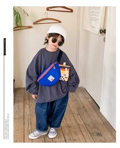Detail of royal blue kids waist bag with cute bubble tea charm and orange zipper
