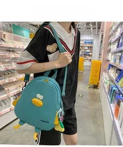 Detail of blue cartoon chick backpack in canvas with yellow 3D beak and feet