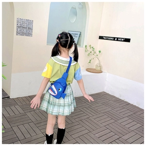 Girl wearing a cute blue shark canvas chest bag in a bright outdoor setting