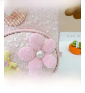 Détail du sac à dos rose à paillettes avec fleurs en dentelle, perles et ours