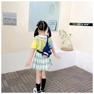 Detail of cute navy blue shark crossbody bag with red mouth on a young girl model