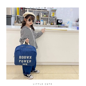 Close-up of kids denim backpack with white letter print on blue denim fabric